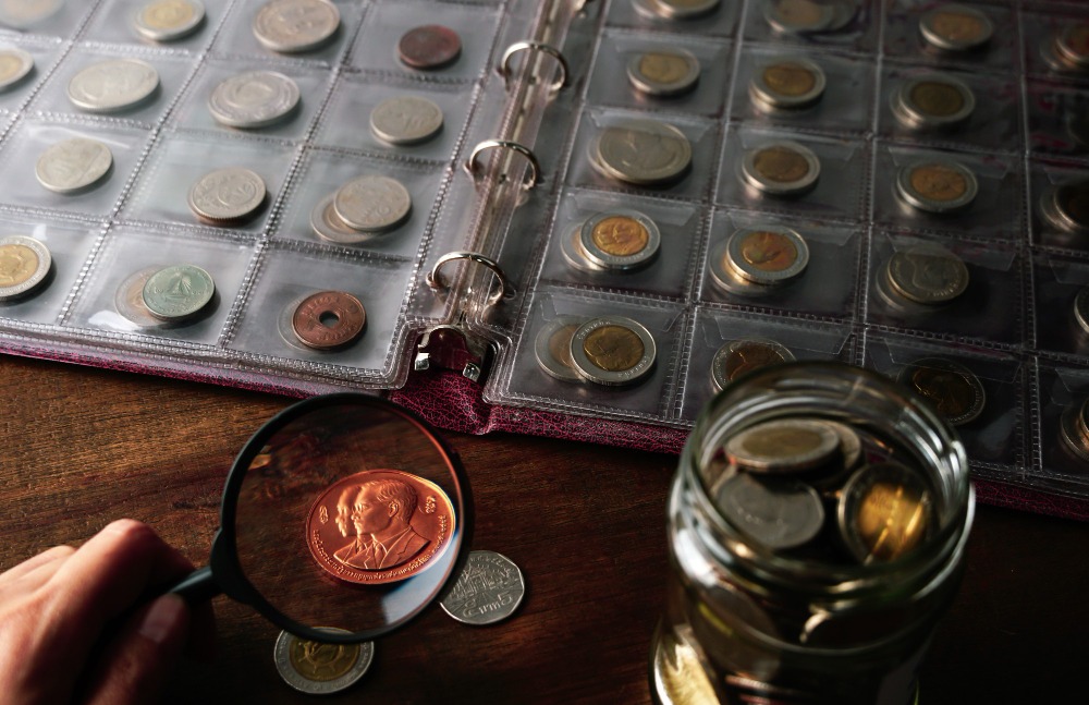 Coin collection — Coin Auctions Collectible coins displayed with a coin album on a wooden table